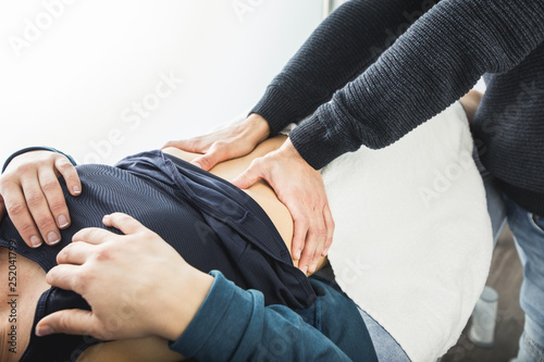 Physiotherapist massaging the belly of a young woman.Concept Physiotherapy