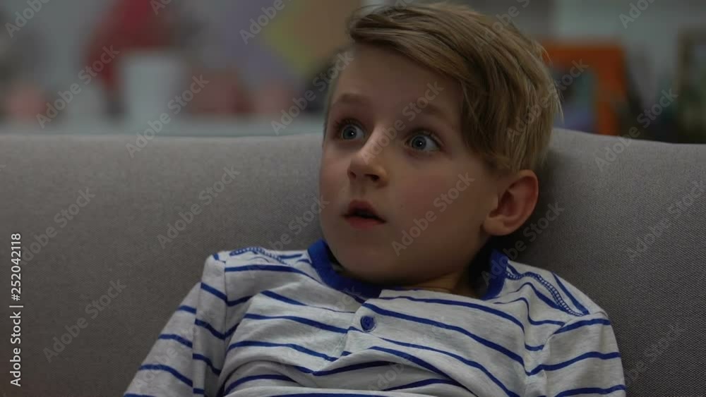 Boy watching horror movie alone at night while parents sleeping, coach potato Boy watching horror movie alone at night while parents sleeping, coach potato