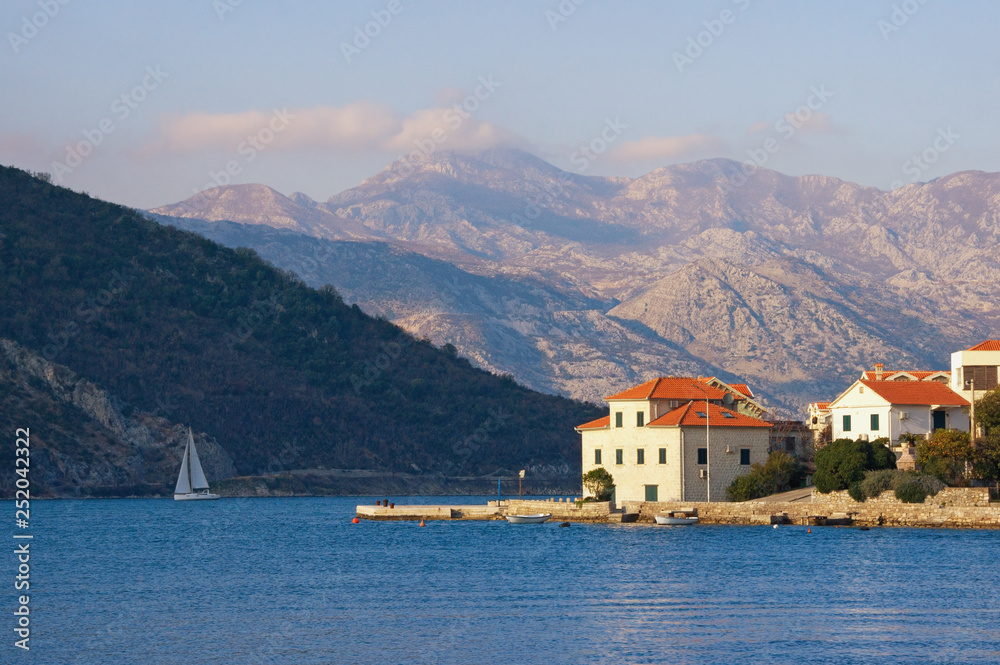 Beautiful winter Mediterranean landscape. Small seaside village at the foot of the mountains. Montenegro, Adriatic Sea, Bay of Kotor, Lepetane village