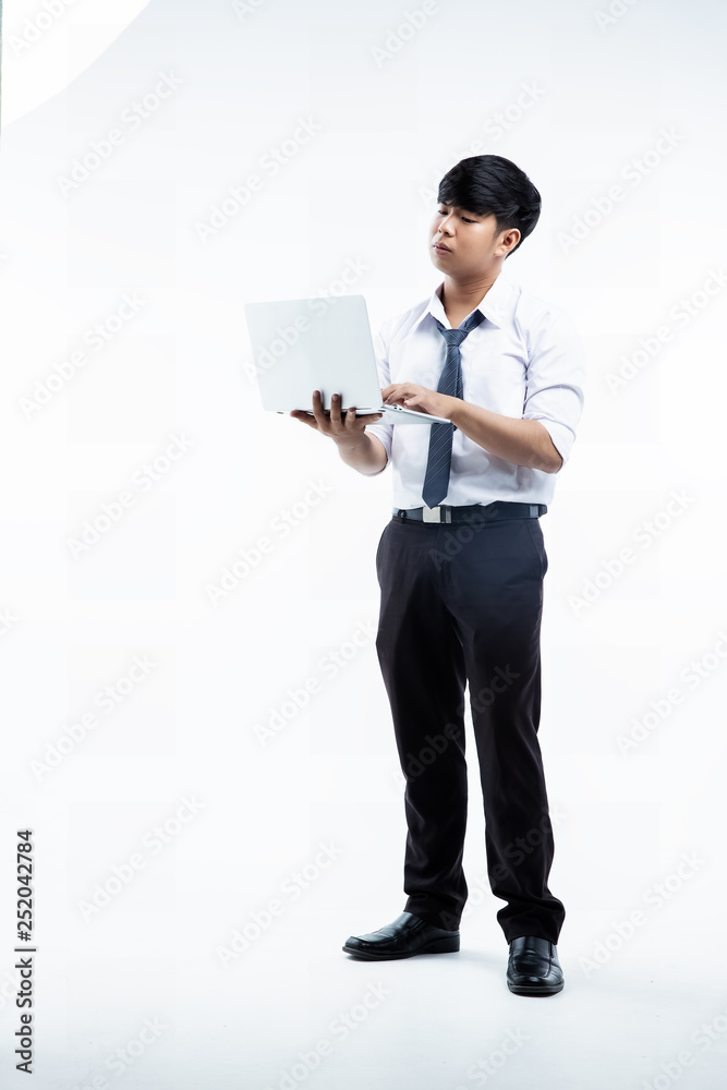 The young student wearing white shirt and long trousers,holding laptop in hand,on white background The young student wearing white shirt and long trousers,holding laptop in hand,on white background