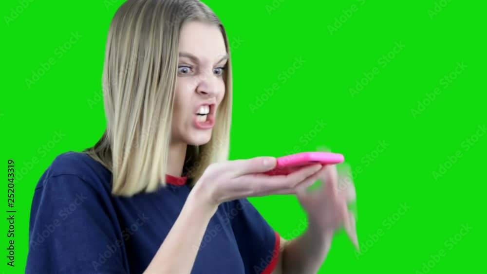 Angry woman screams into the phone on green background. Chroma key Angry woman screams into the phone on green background. Chroma key