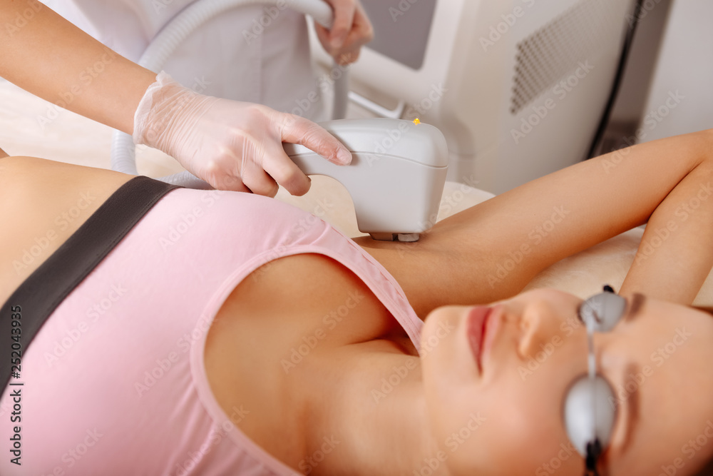 Naklejka premium Professional depilatory master making photo hair removal from armpits