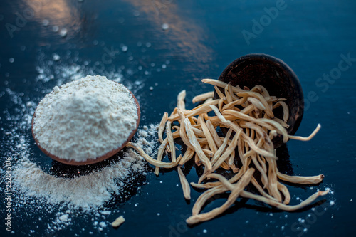 Popular Indian & Asian ayurvedic organic herb musli Safed Moosli/ Shaqaqule/ Dholi Musli/ Khiruva/ Shedheveli/ Swetha Musli/ Taniravi Thang/ in a clay bowl on wooden surface with its powder also.