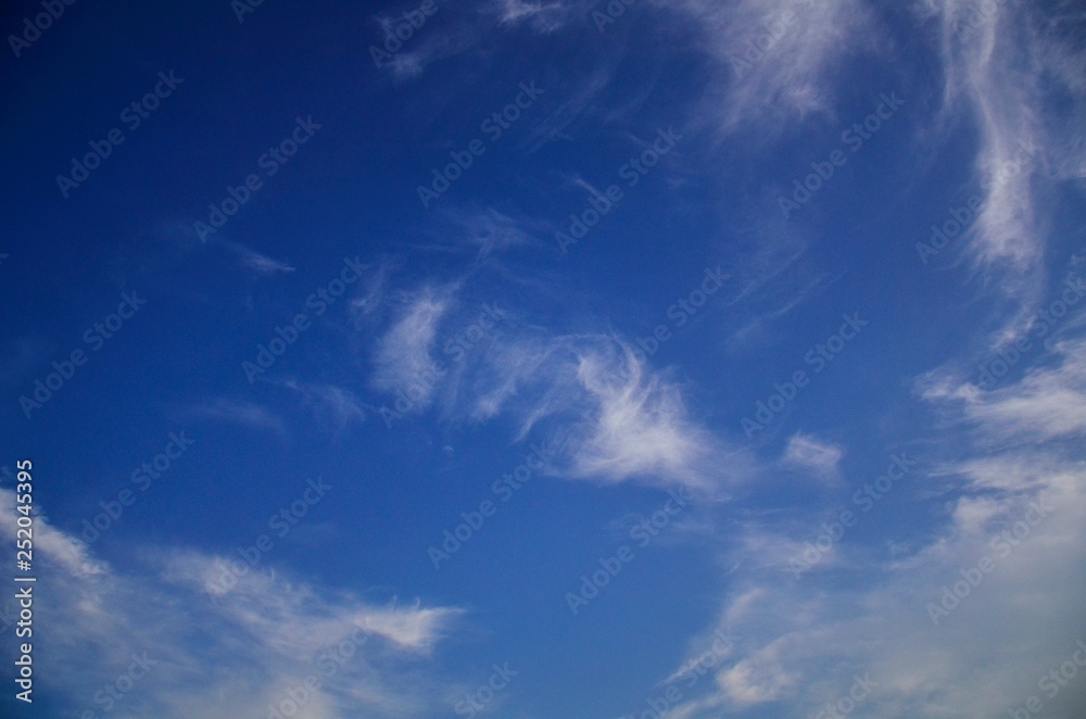 Obraz premium Beautiful natural pattern of white clouds and blue sky. Waving white clouds and consecutive blue color from bright to dark with freedom.