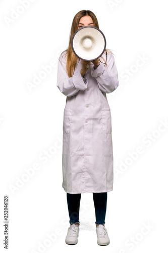 Full body Young doctor woman shouting through a megaphone to announce something on isolated background