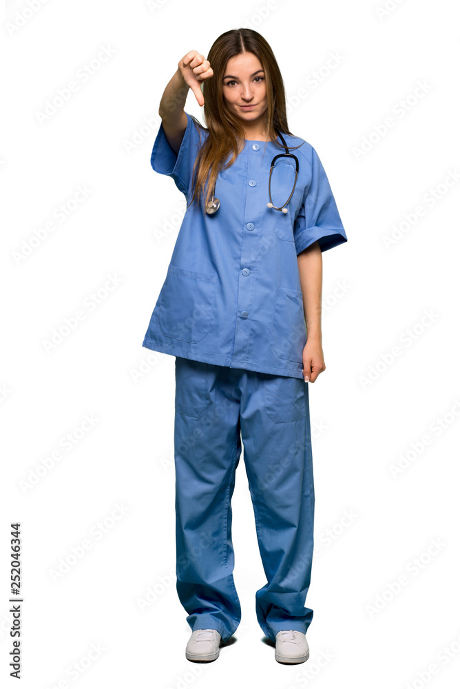 Full body Young nurse showing thumb down sign with negative expression on isolated background Full body Young nurse showing thumb down sign with negative expression on isolated background