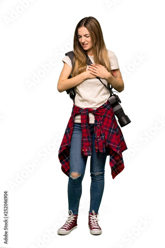 Full body Young photographer woman having a pain in the heart on isolated background