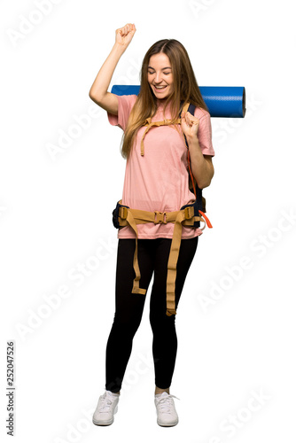 Full body Young backpacker woman celebrating a victory on isolated background