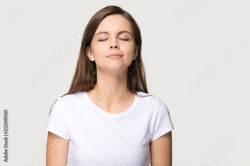 Happy calm girl enjoying good smell breathing fresh air isolated  photo