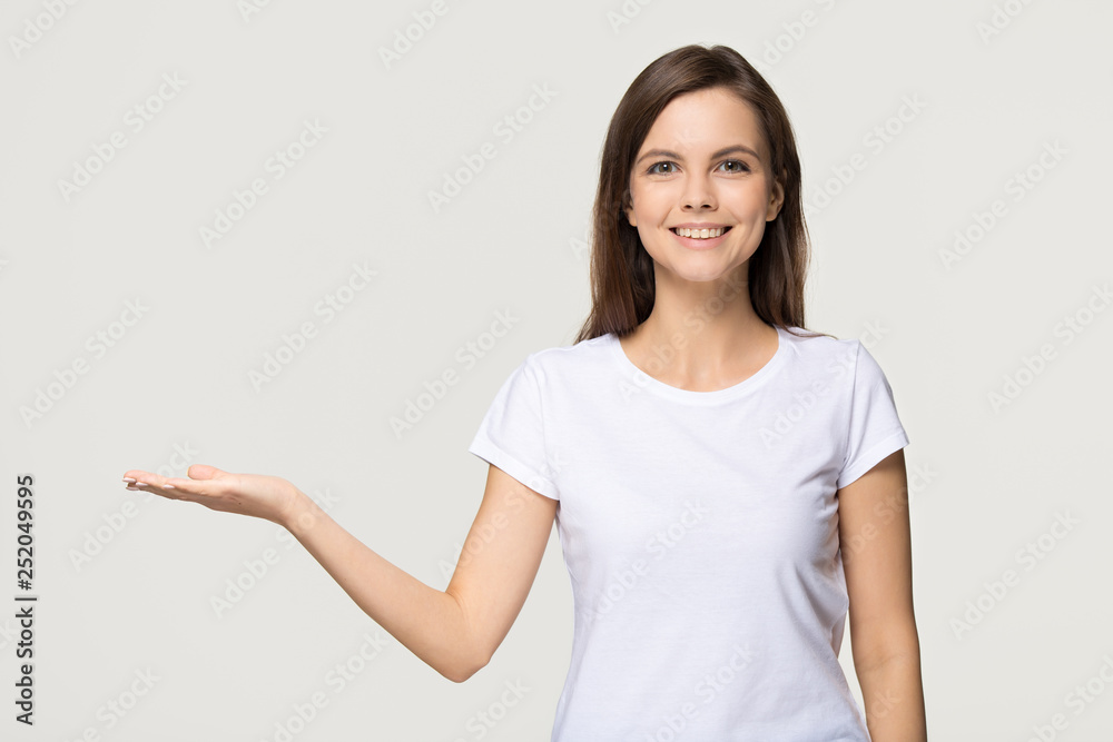 Happy girl holding copy space advertising isolated on grey background Happy girl holding copy space advertising isolated on grey background