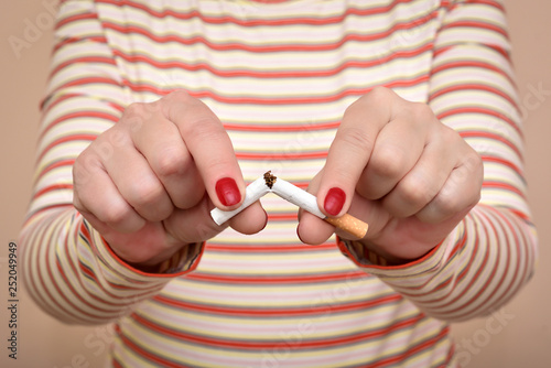 Hands of a woman breaking a cigarette. Stop smoking concept. 