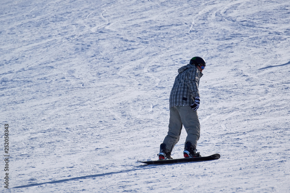 young man with a mustache in ski equipment snowboarding on a mountainside on a sunny day. copy space young man with a mustache in ski equipment snowboarding on a mountainside on a sunny day. copy space