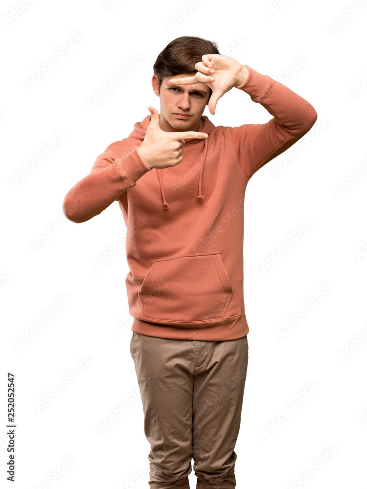 Teenager man with sweatshirt focusing face. Framing symbol over isolated white background Teenager man with sweatshirt focusing face. Framing symbol over isolated white background