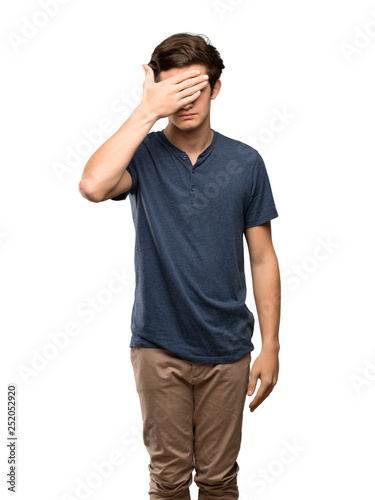 Teenager man covering eyes by hands. Do not want to see something over isolated white background