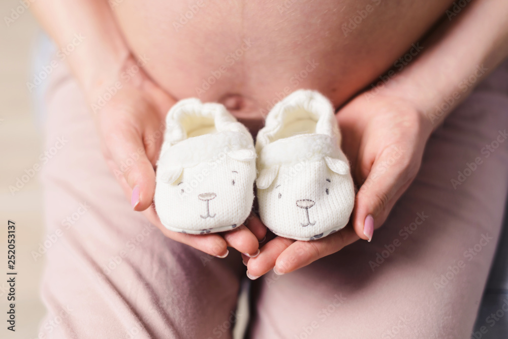 Lovely hands of pretty beautiful young pregnant woman in sportswear at home. Waiting for a baby future mother concept Lovely hands of pretty beautiful young pregnant woman in sportswear at home. Waiting for a baby future mother concept