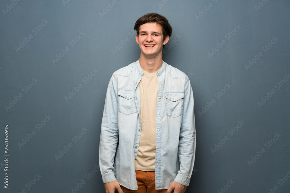 Obraz premium Teenager man with jean jacket over grey wall smiling