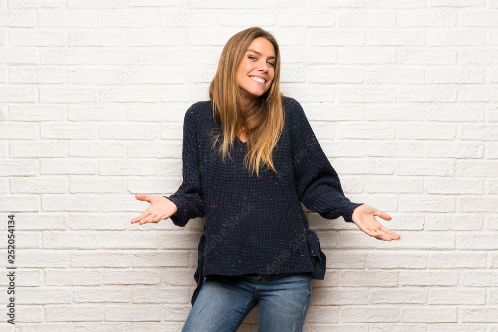 Blonde woman over brick wall smiling Blonde woman over brick wall smiling