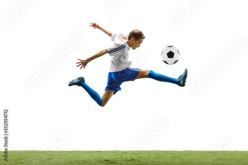 Young boy with soccer ball running and jumping isolated on white studio background. Junior football soccer player in motion © master1305