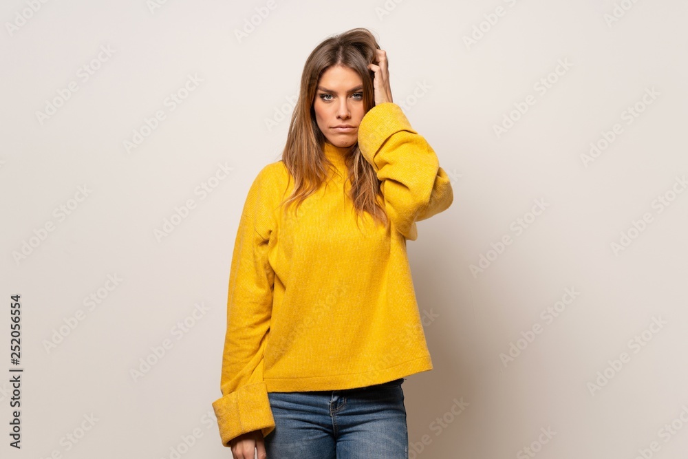 Woman with yellow sweater over isolated wall with an expression of frustration and not understanding Woman with yellow sweater over isolated wall with an expression of frustration and not understanding