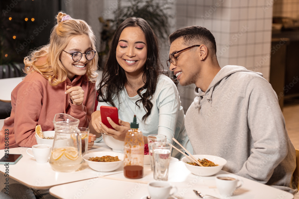 Asian girl showing photos with her boyfriend to two her friends. Asian girl showing photos with her boyfriend to two her friends.