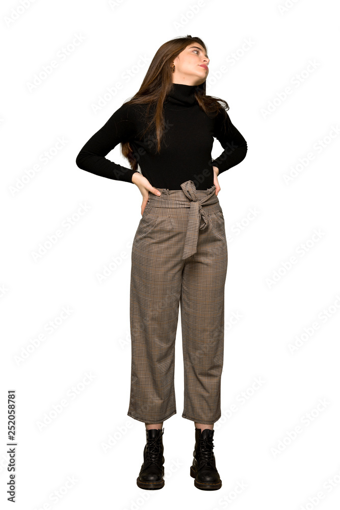 Full-length shot of Pretty girl suffering from backache for having made an effort on isolated white background Full-length shot of Pretty girl suffering from backache for having made an effort on isolated white background