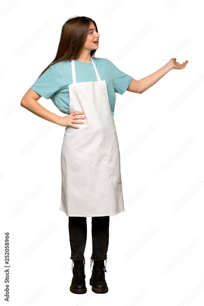 Full-length shot of Girl with apron pointing back and presenting a product on isolated white background Full-length shot of Girl with apron pointing back and presenting a product on isolated white background