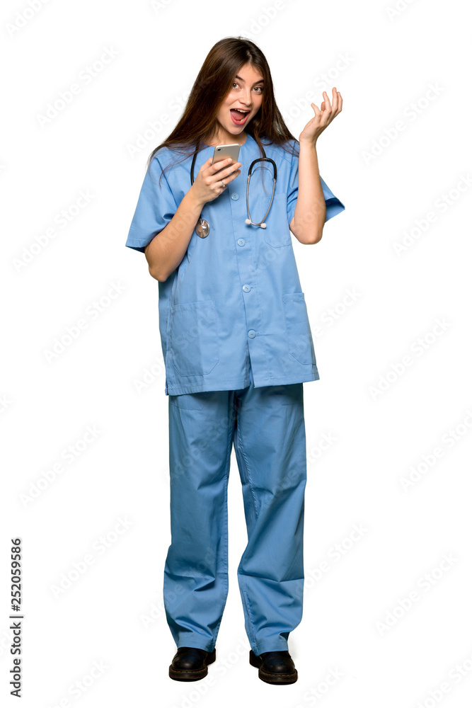 Full-length shot of Young nurse surprised while sending a message with the mobile on isolated white background