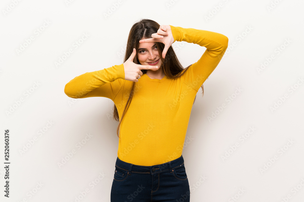 Young woman with yellow sweater focusing face. Framing symbol