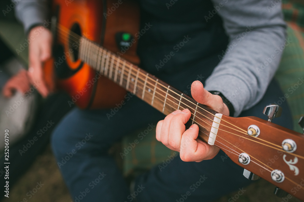 Playing on the shitara. Guitar. Guy with a guitar in his hand