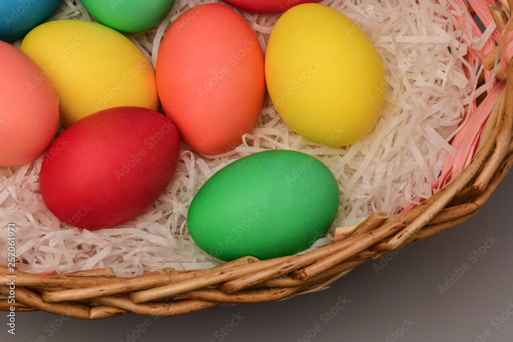 Easter colored eggs in nest on grey background Easter colored eggs in nest on grey background