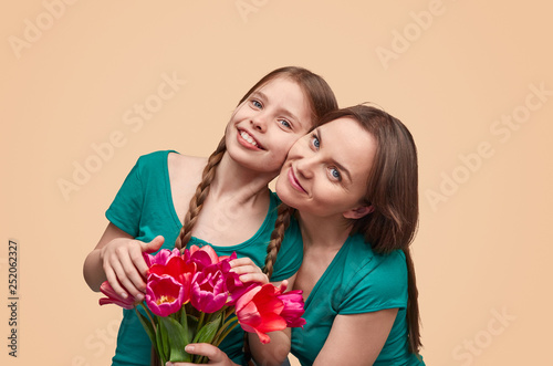 Mother and daughter with flowers posing for camera