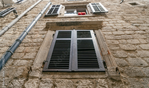 Old european building window with wooden blinds