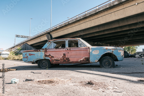 Scrap car under a bridge