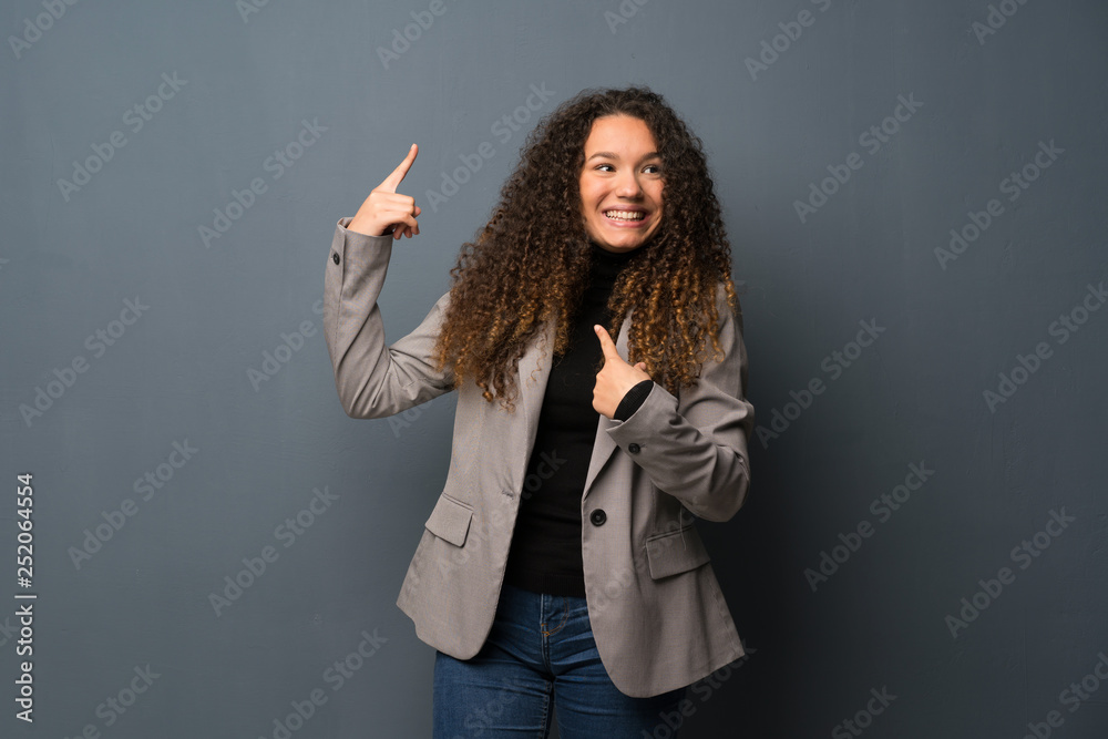 Teenager girl over blue wall with surprise facial expression