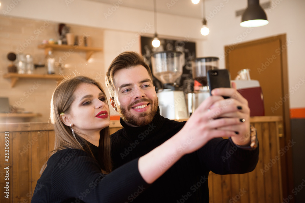 Smiling Woman And Handsome Man Drinking Coffee, Using Mobile Phone While Spending Time In A Coffee Shop.