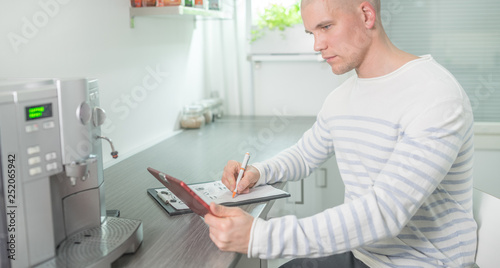 Man working in the kitchen using tablet