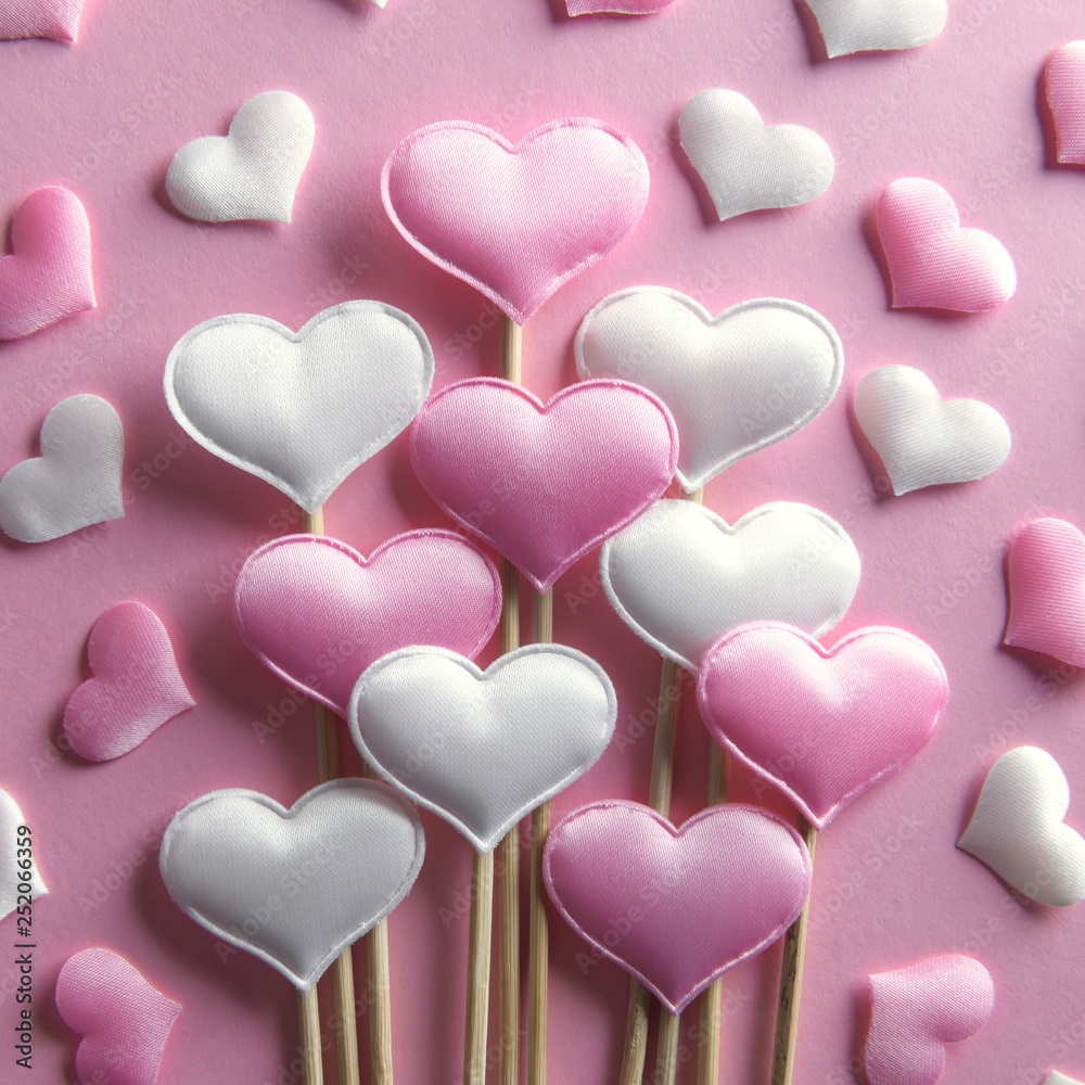 Pink textile hearts on wooden sticks closeup. Valentines day background, creative texture and love concept