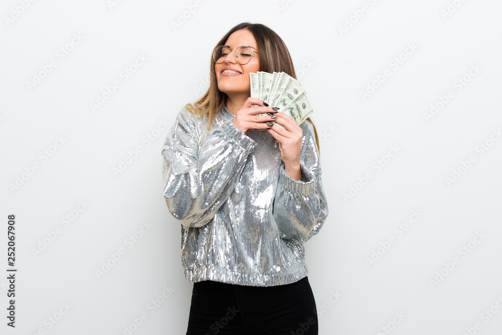 Young woman with glasses over white wall taking a lot of money Young woman with glasses over white wall taking a lot of money