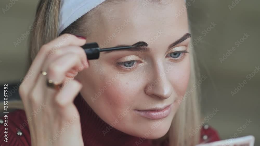 Blonde girl paints her eyebrows. Blonde girl paints her eyebrows.