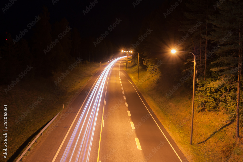 Long exposure photo of traffic with blurred traces from cars at night in Finland, top view.