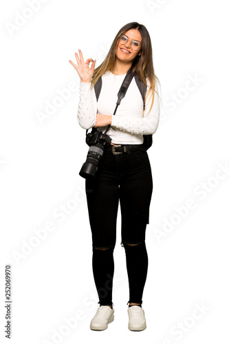 Full body of Young photographer woman showing an ok sign with fingers