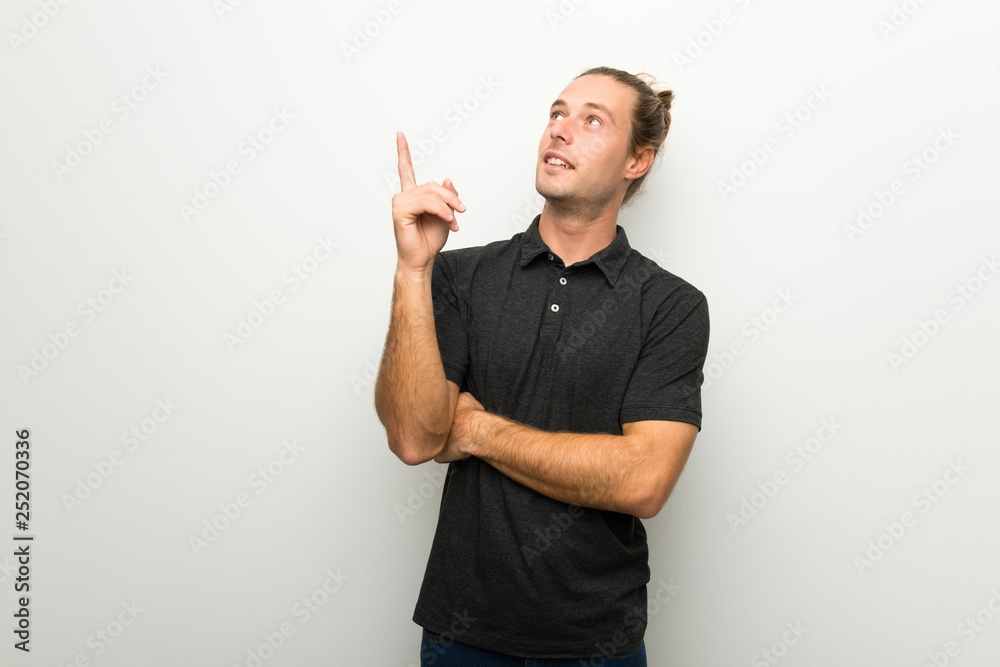 Blond man with long hair over white wall pointing a great idea and looking up Blond man with long hair over white wall pointing a great idea and looking up