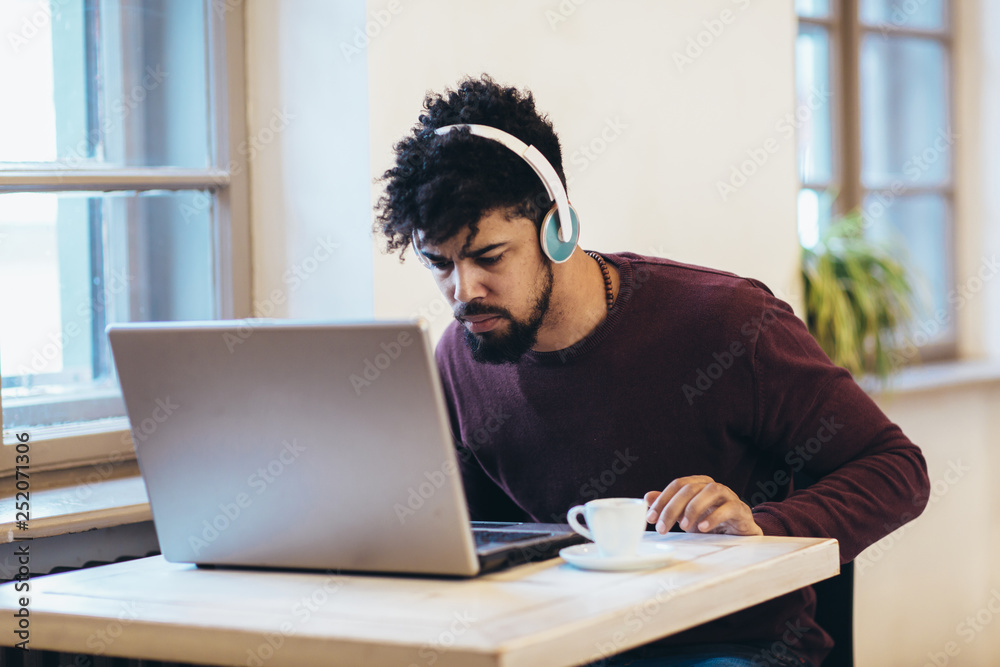 Man in front of laptop computer with headset Man in front of laptop computer with headset