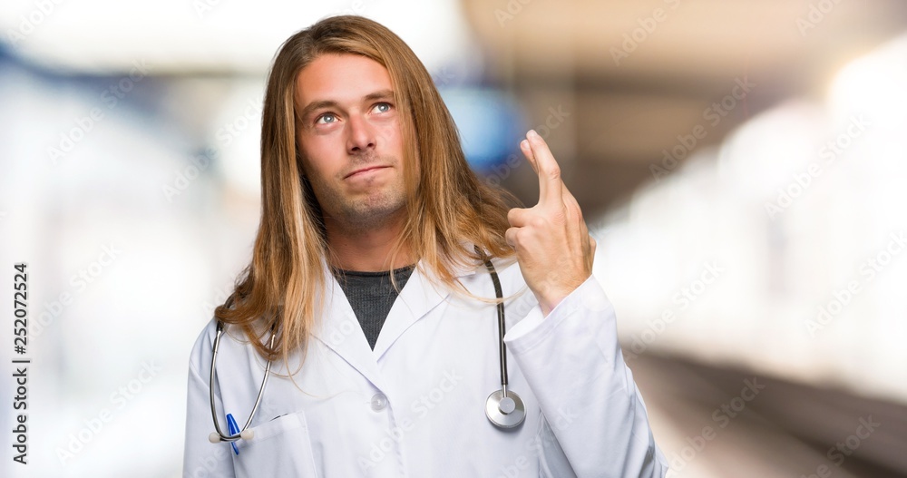 Doctor man with fingers crossing and wishing the best in a hospital Doctor man with fingers crossing and wishing the best in a hospital