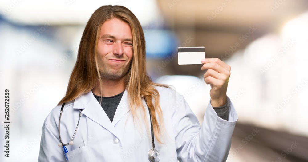 Doctor man taking a credit card without money in a hospital Doctor man taking a credit card without money in a hospital