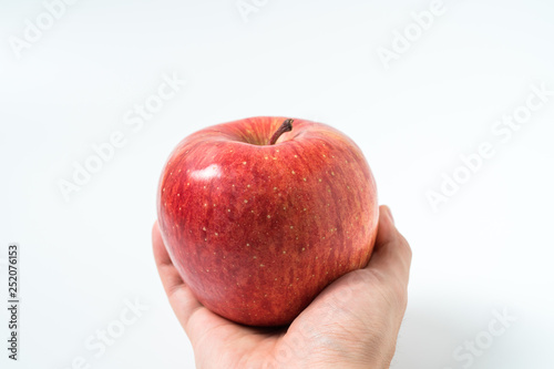 Holding an apple in the hand from below isolated on white background