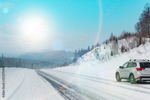 Suv car stay on roadside of winter road. Family trip to ski resort concept. Winter or spring holidays adventure. car on winter snowy road