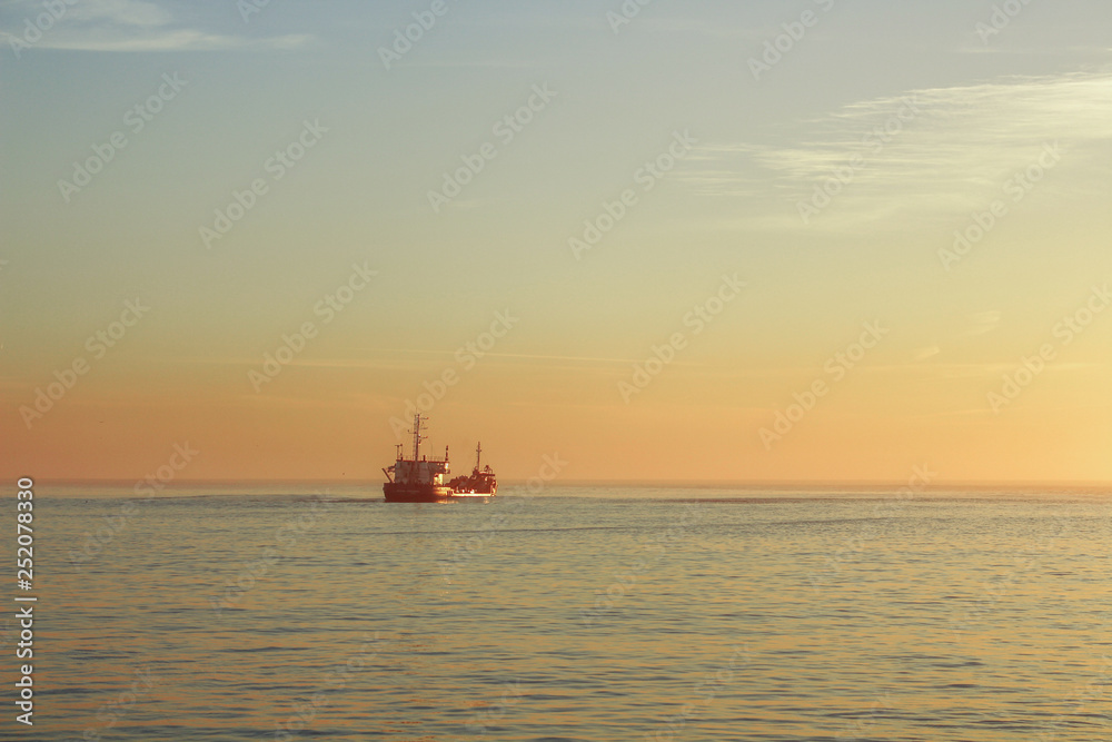 Boat on the ocean with sunset colors