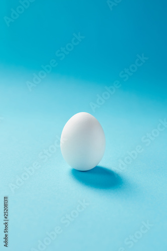 White egg easter on the blue background. Design, visual art, minimalist copy space