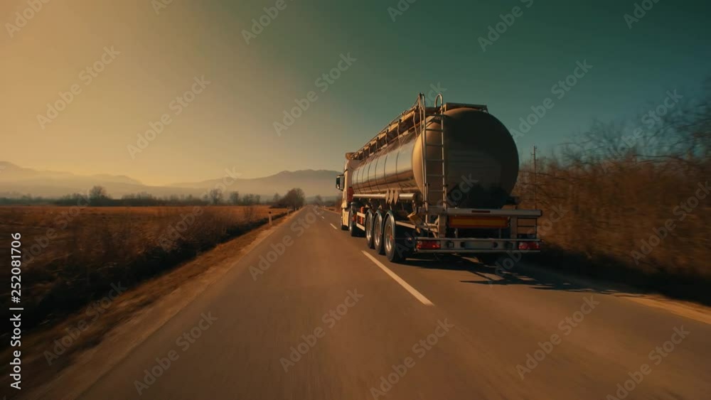 Low angle shot of the back of a driving gasoline tanker truck Low angle shot of the back of a driving gasoline tanker truck